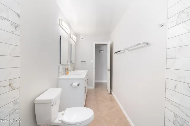 a bathroom with a sink a toilet a mirror and shower