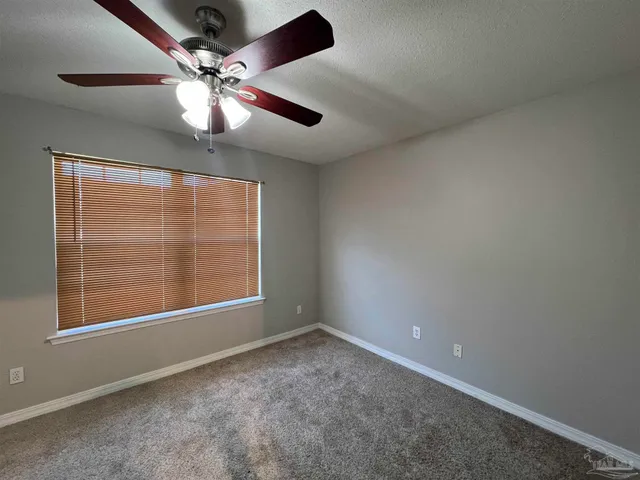 an empty room with closet and a chandelier fan