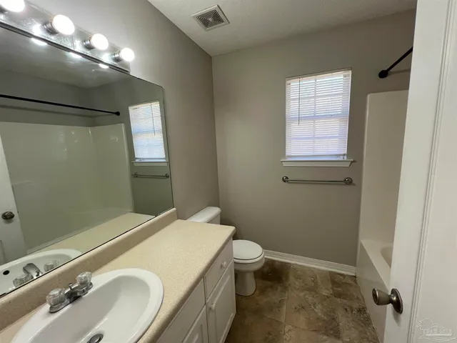 a bathroom with a tub a sink and a mirror