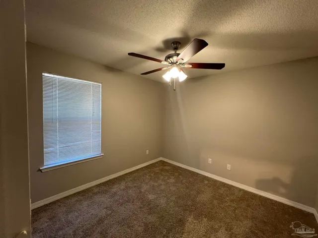 an empty room with closet and a chandelier fan