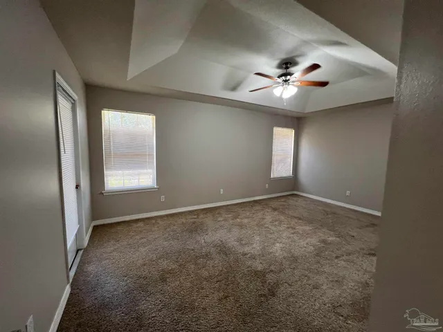a view of a hallway with wooden floor and a bathroom