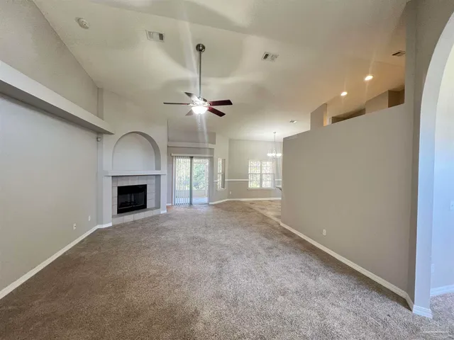 an empty room with fireplace and windows