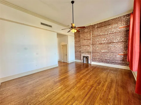 a view of empty room with wooden floor and fireplace