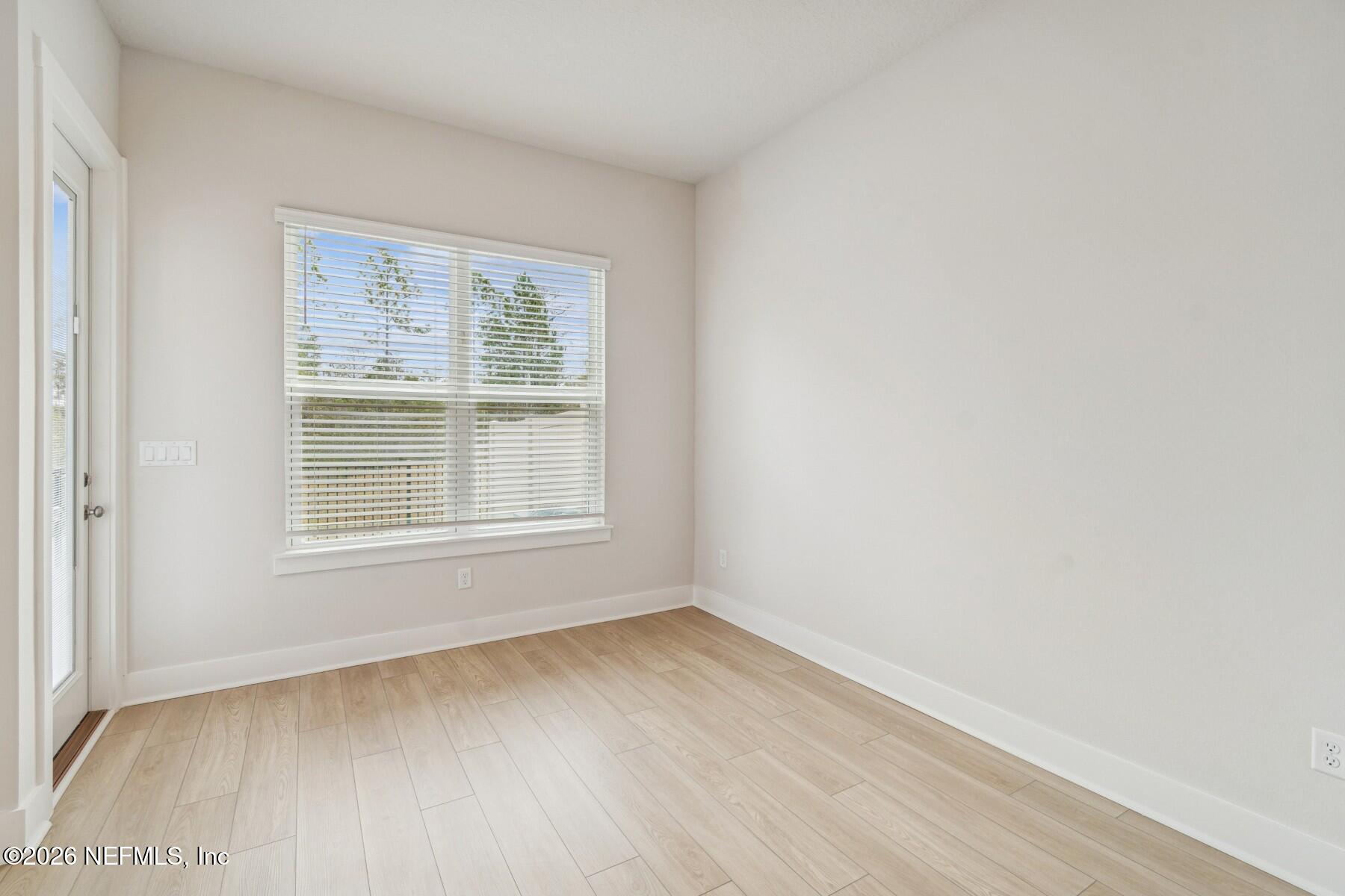 10131 Element Road Jacksonville, FL 32256 - Photo 11 of 28 a view of an empty room with wooden floor and a window