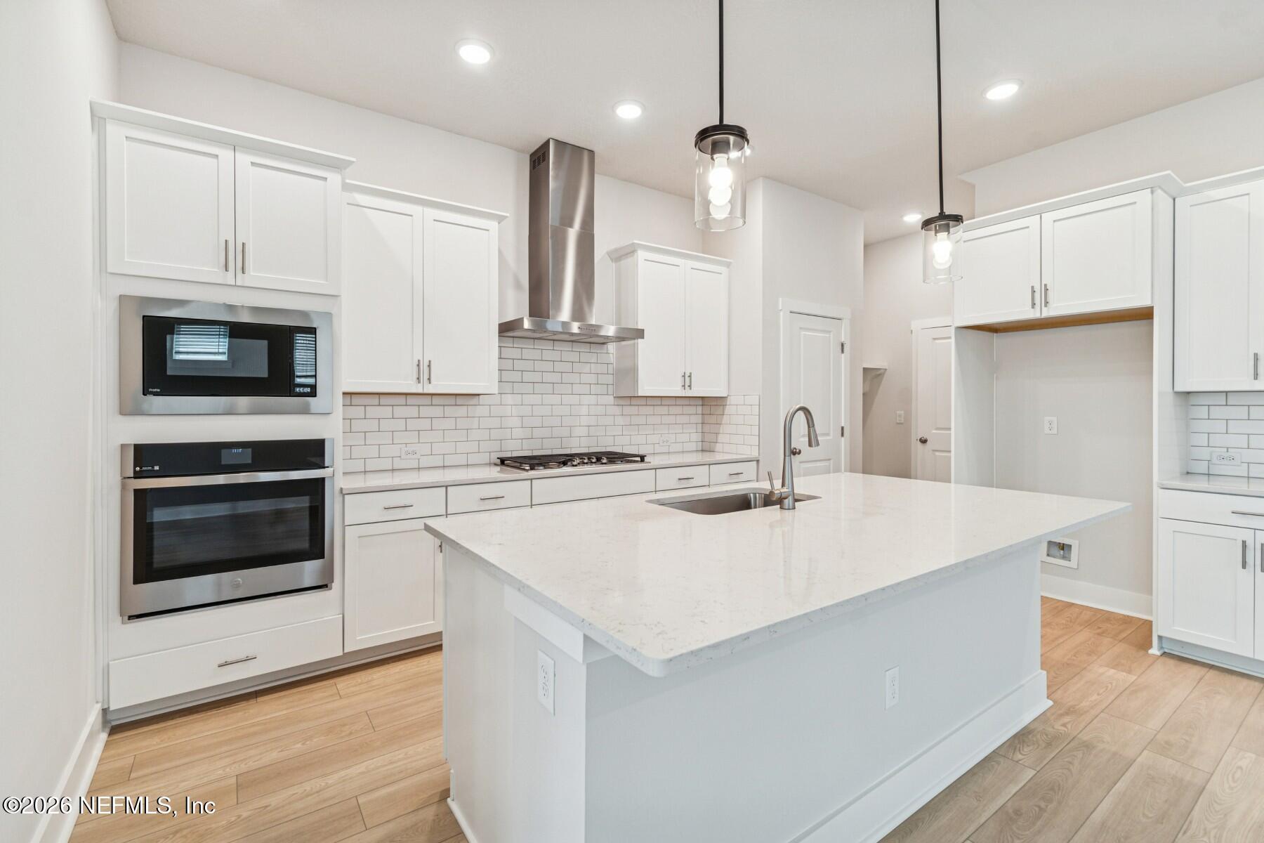 10131 Element Road Jacksonville, FL 32256 - Photo 2 of 28 a kitchen with stainless steel appliances kitchen island a white cabinets and wooden floor
