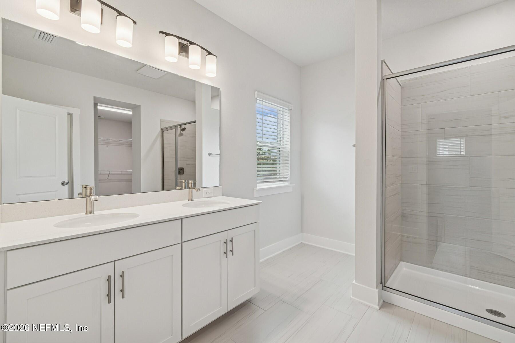 10131 Element Road Jacksonville, FL 32256 - Photo 22 of 28 a bathroom with a double vanity sink mirror and shower