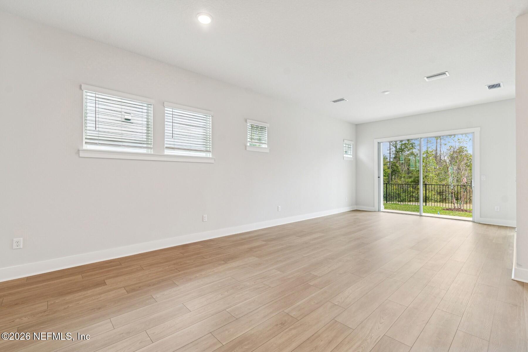 10131 Element Road Jacksonville, FL 32256 - Photo 9 of 28 a view of an empty room with wooden floor and a window