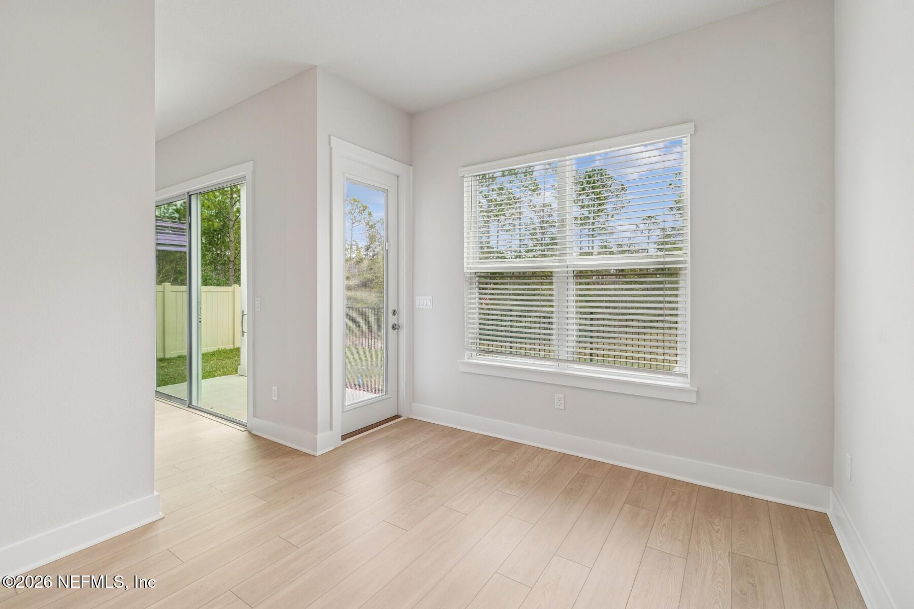 10131 Element Road Jacksonville, FL 32256 - Photo 10 of 28 a view of an empty room with wooden floor and a window
