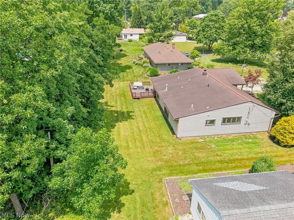 8160 Joyce Road Broadview Heights, OH 44147 - Photo 35 of 45 Expansive residential property featuring a large green lawn, mature trees along the perimeter, and a multi-level wood deck