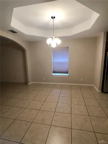 a view of a room with a chandelier fan and tiles