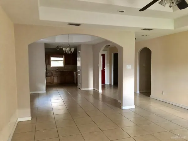 a view of a hallway with entryway chandelier and livingroom view