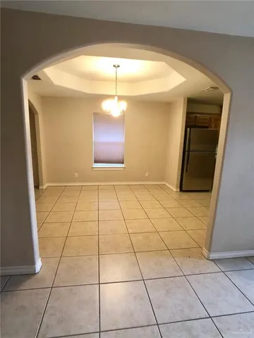 a view of a livingroom with wooden floor and a refrigerator