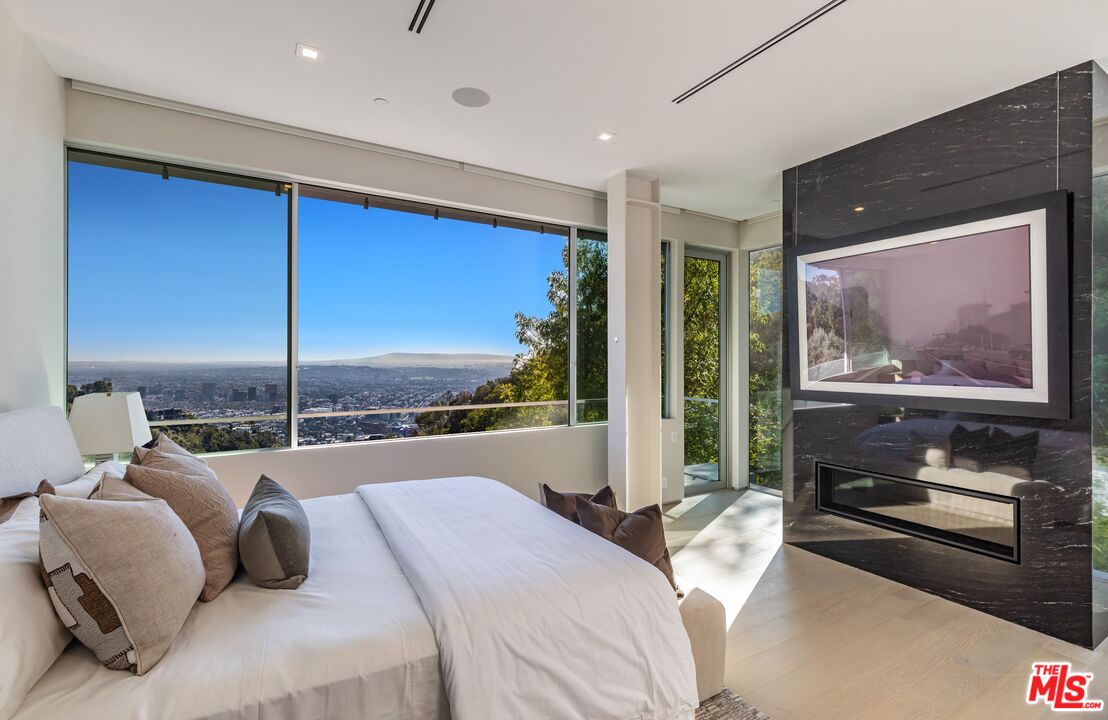 1895 Rising Glen Road Los Angeles, CA 90069 - Photo 16 of 41 a bedroom with a large bed and a balcony view