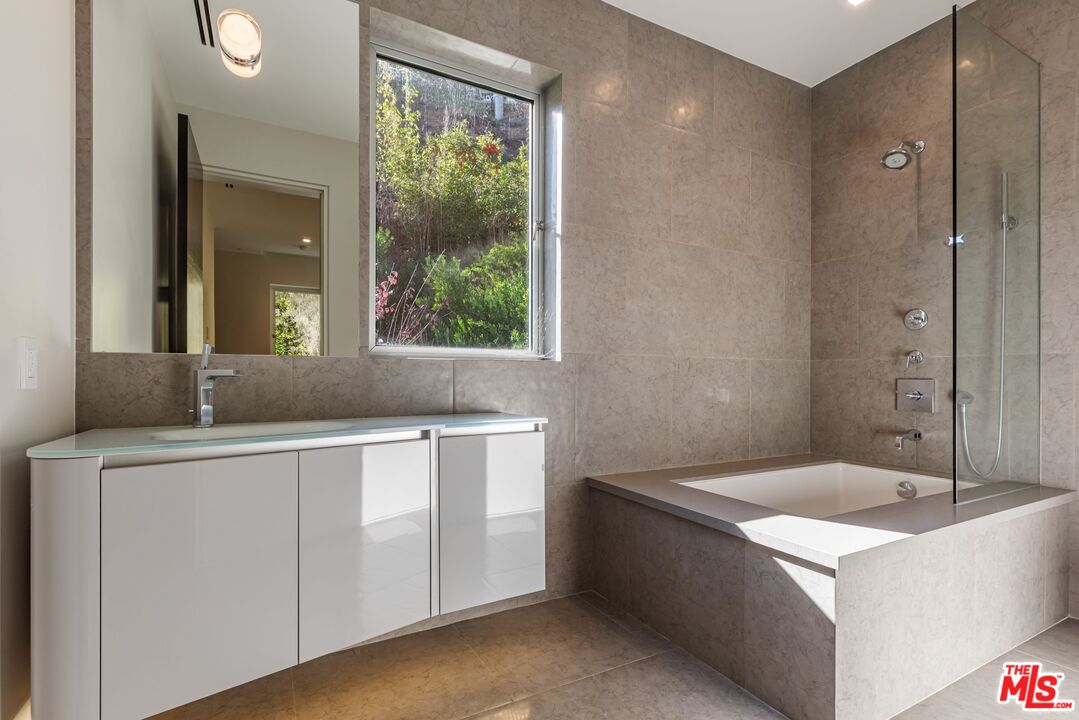 1895 Rising Glen Road Los Angeles, CA 90069 - Photo 23 of 41 a bathroom with a tub sink and mirror
