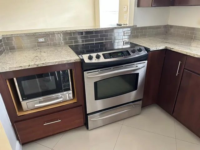 a stove top oven sitting inside of a kitchen