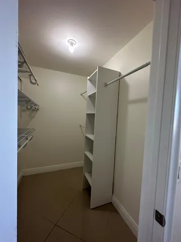 a view of walk in closet with empty racks