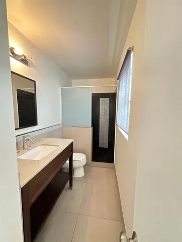 a spacious bathroom with a granite countertop sink and a mirror