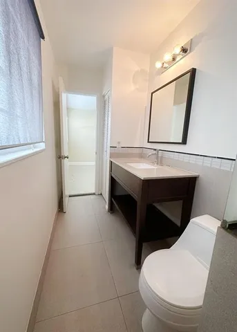 a bathroom with a toilet sink and mirror