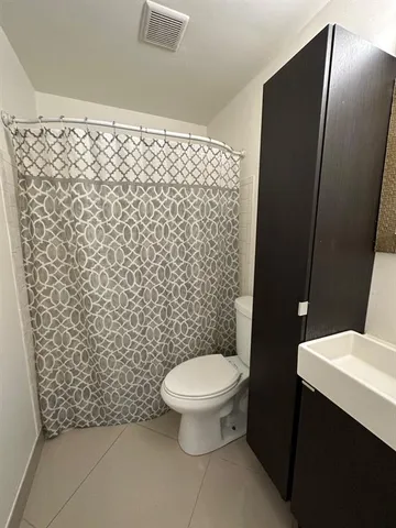 a bathroom with a toilet and a shower curtain