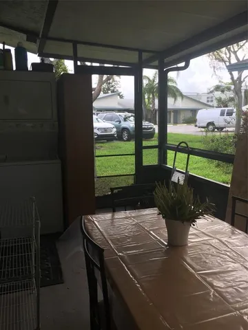 a view of a patio with dining table and chairs with a yard