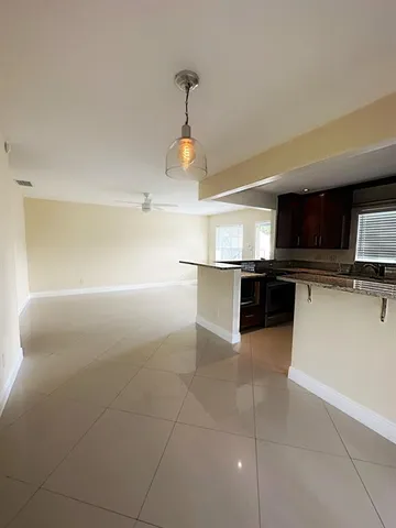 a kitchen with stainless steel appliances granite countertop a sink and a stove top oven with wooden floor
