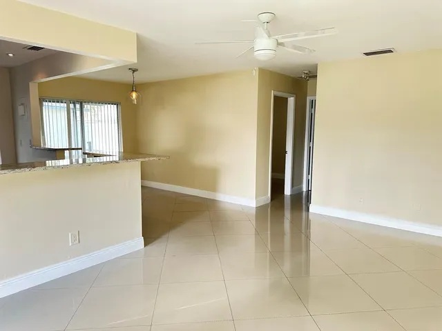 a view of an empty room with window and bathroom