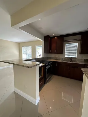 a kitchen with granite countertop a stove a sink and a microwave