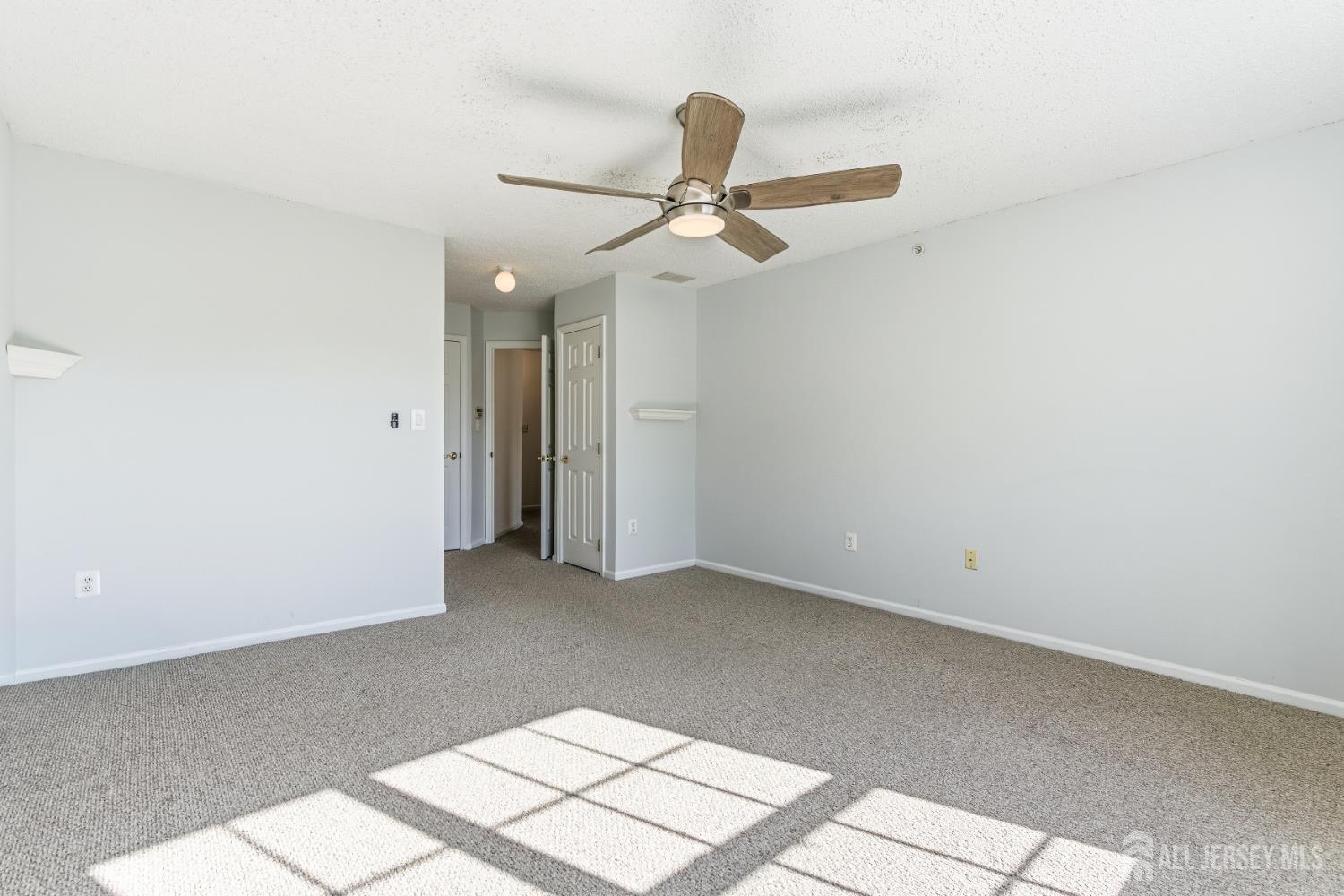 21 Newburgh Drive Edison, NJ 08820 - Photo 15 of 31 an empty room with a ceiling fan and carpet