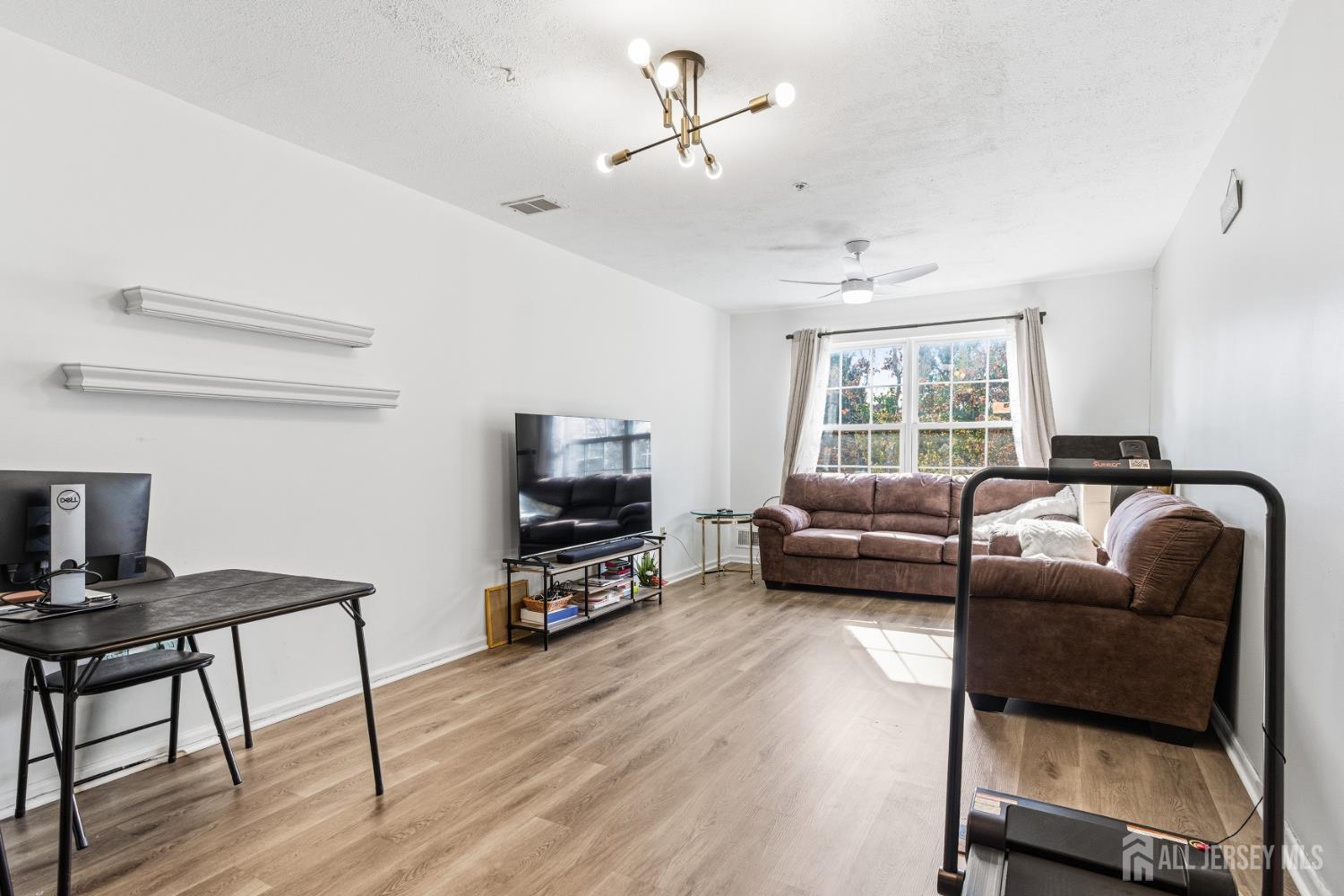 21 Newburgh Drive Edison, NJ 08820 - Photo 5 of 31 a living room with furniture a flat screen tv and a window