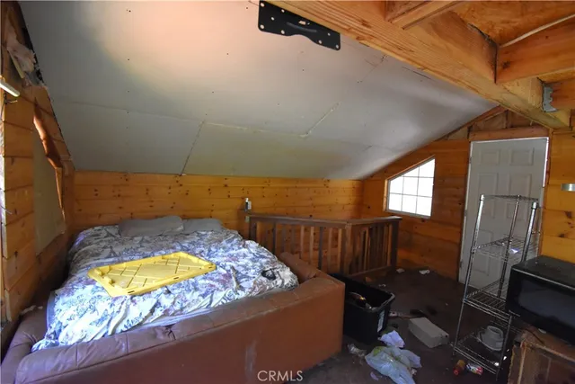a backyard of a house with large trees and wooden fence
