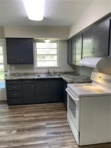 a kitchen with granite countertop a sink and a stove