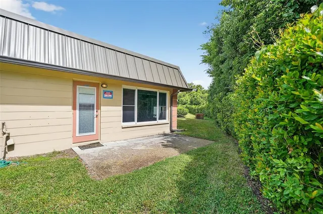 a porch with a table and chairs next to a yard