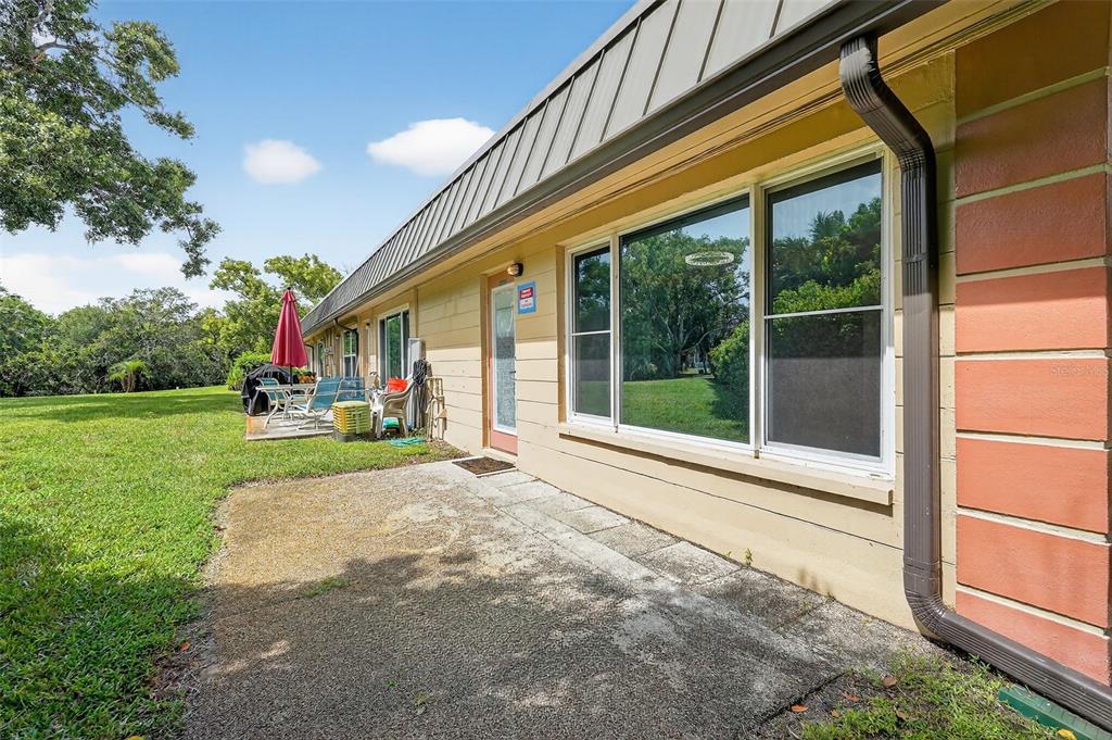 4301 Summersun Drive, Unit A New Port Richey, FL 34652 - Photo 33 of 35 a porch with a table and chairs next to a yard