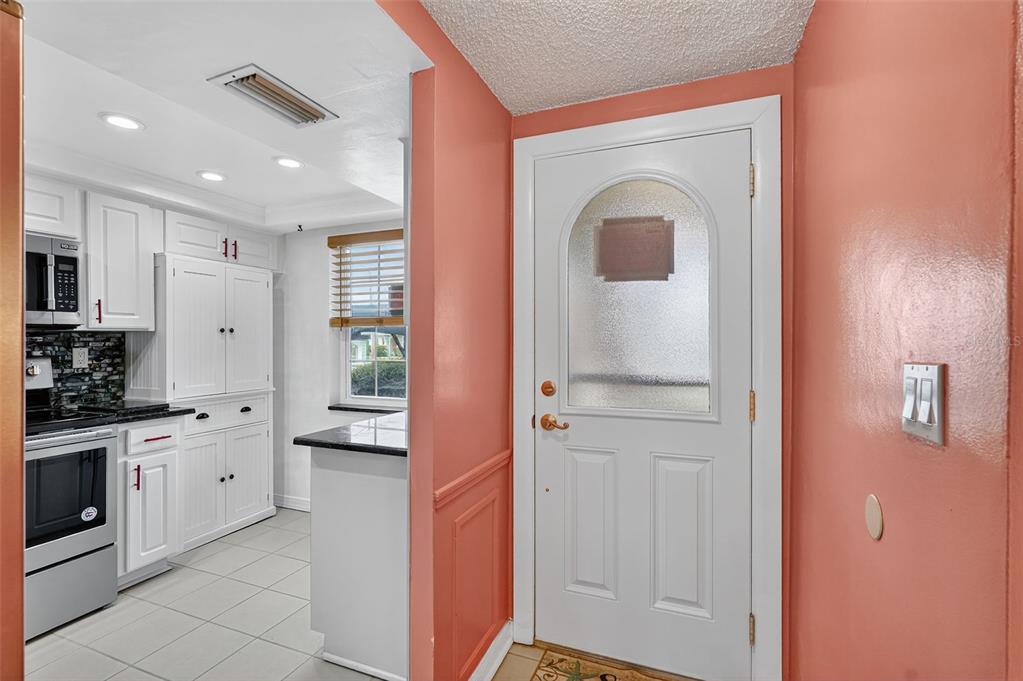 4301 Summersun Drive, Unit A New Port Richey, FL 34652 - Photo 7 of 35 a hallway with cabinets a stove and a window