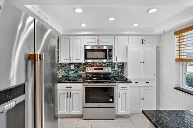 a kitchen with stainless steel appliances white cabinets and a stove