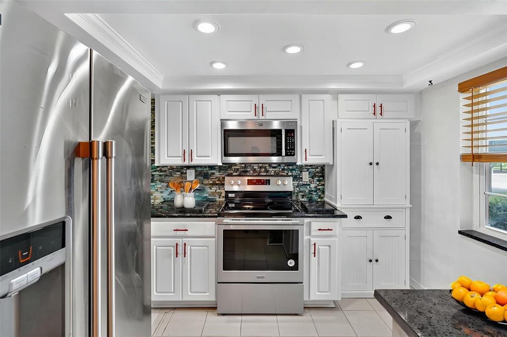 4301 Summersun Drive, Unit A New Port Richey, FL 34652 - Photo 9 of 35 a kitchen with stainless steel appliances white cabinets and a stove