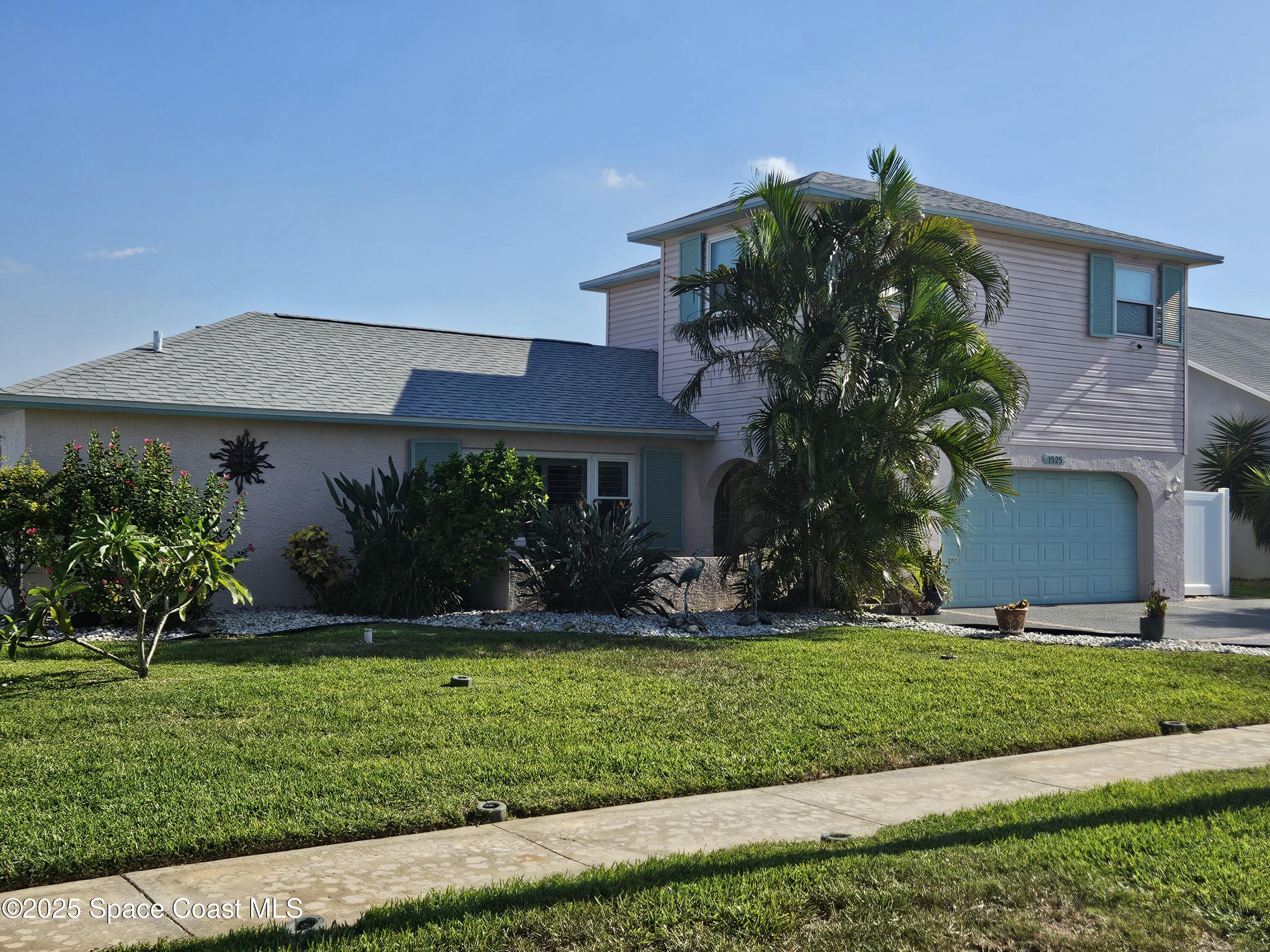 1525 West Riviera Drive Merritt Island, FL 32952 - Photo 2 of 47 a front view of a house with a yard