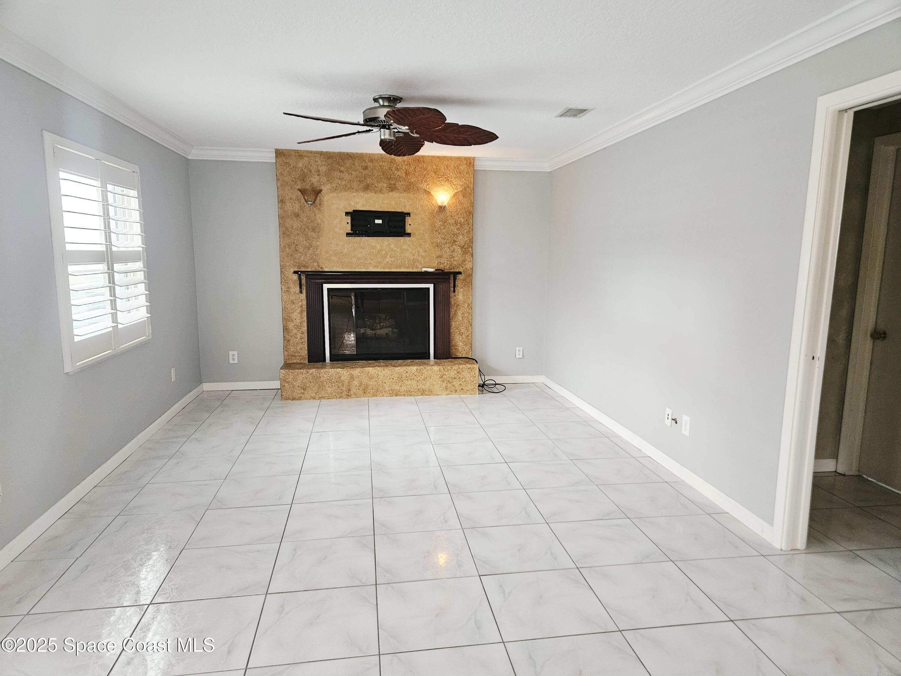 1525 West Riviera Drive Merritt Island, FL 32952 - Photo 25 of 47 a view of an empty room with a fireplace and a window