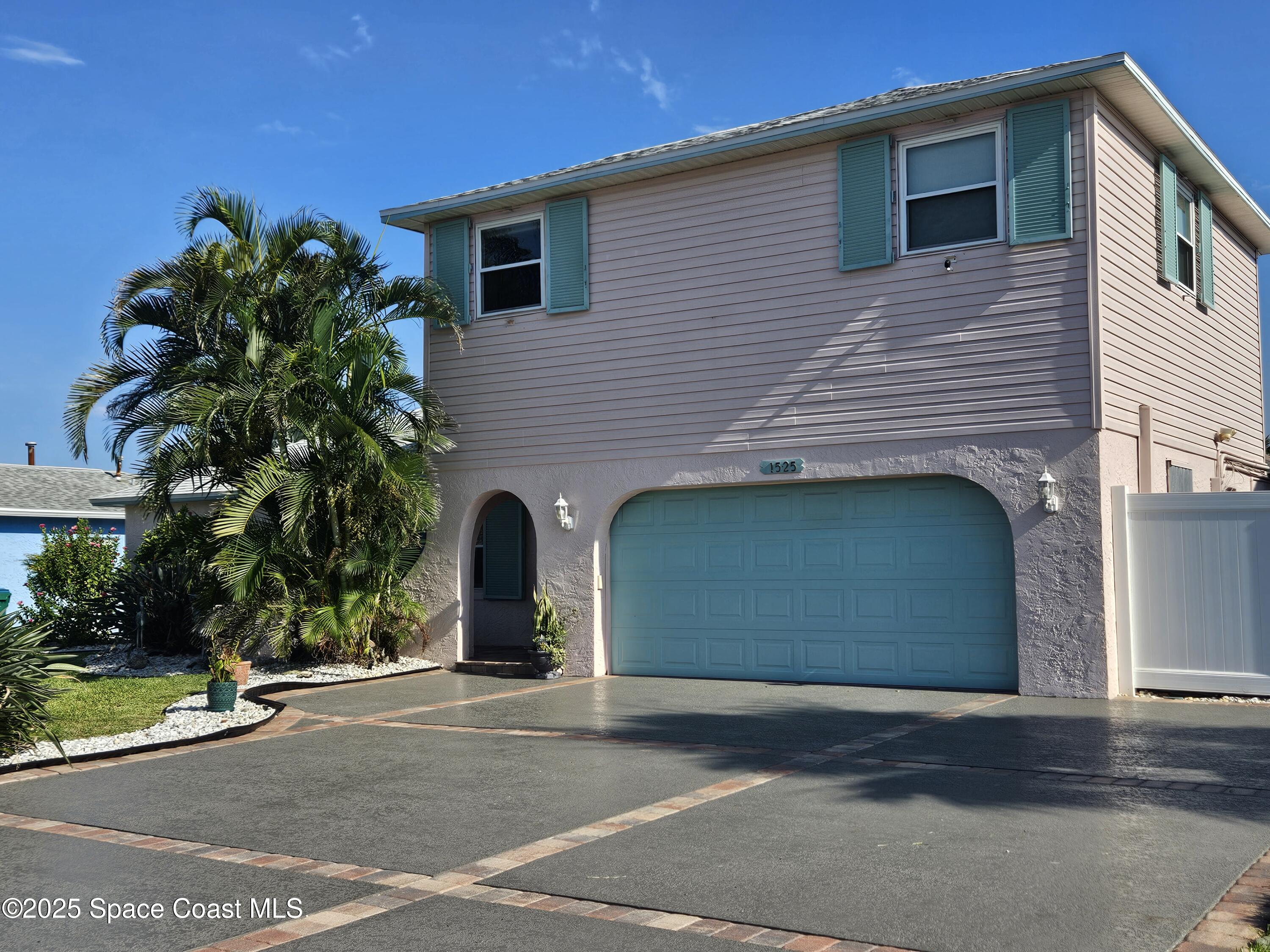 1525 West Riviera Drive Merritt Island, FL 32952 - Photo 42 of 47 a front view of a house with a yard and garage
