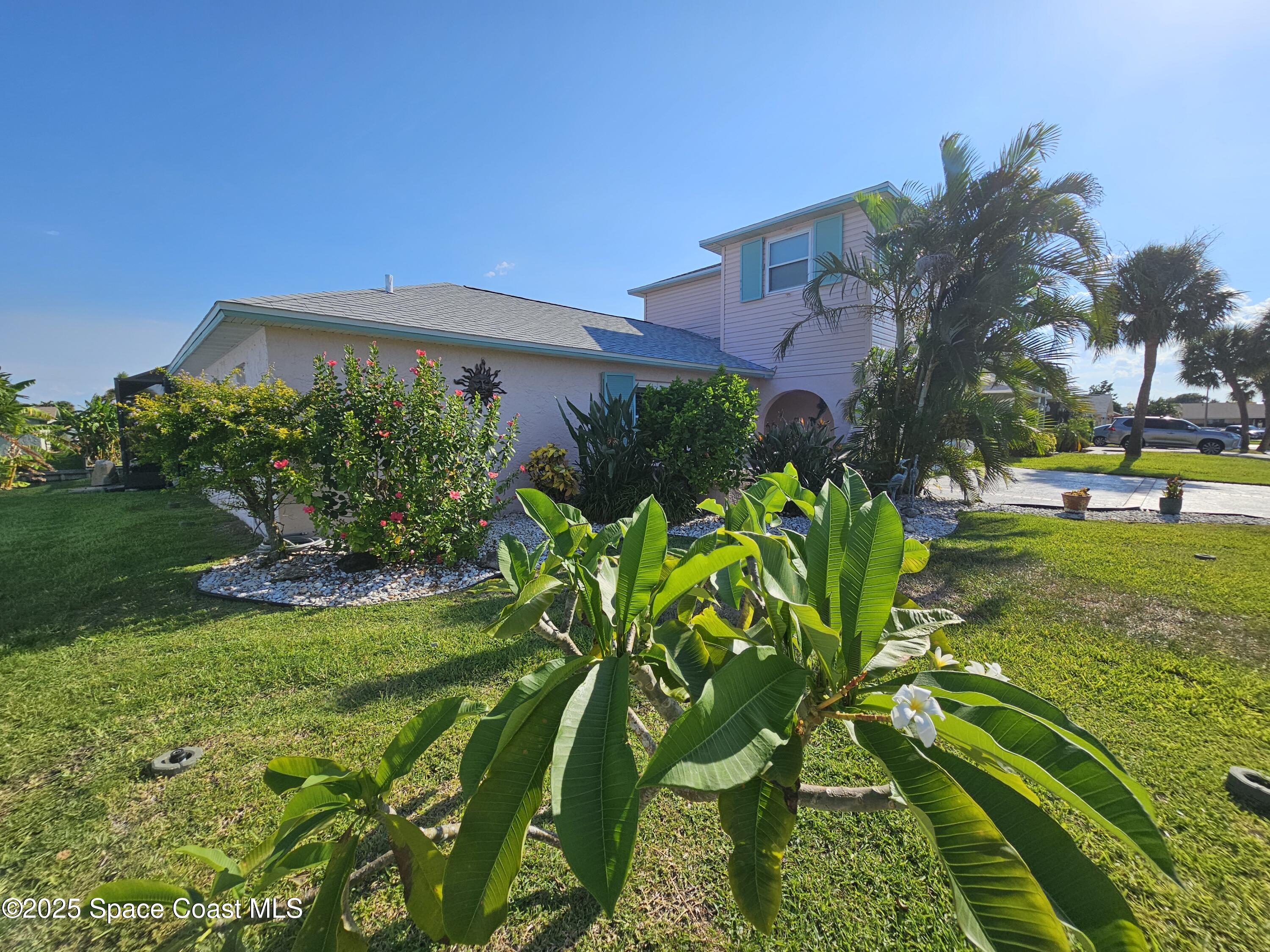 1525 West Riviera Drive Merritt Island, FL 32952 - Photo 5 of 47 a view of a garden with a building in the background