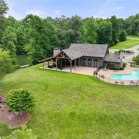 a white house with a small yard and large trees