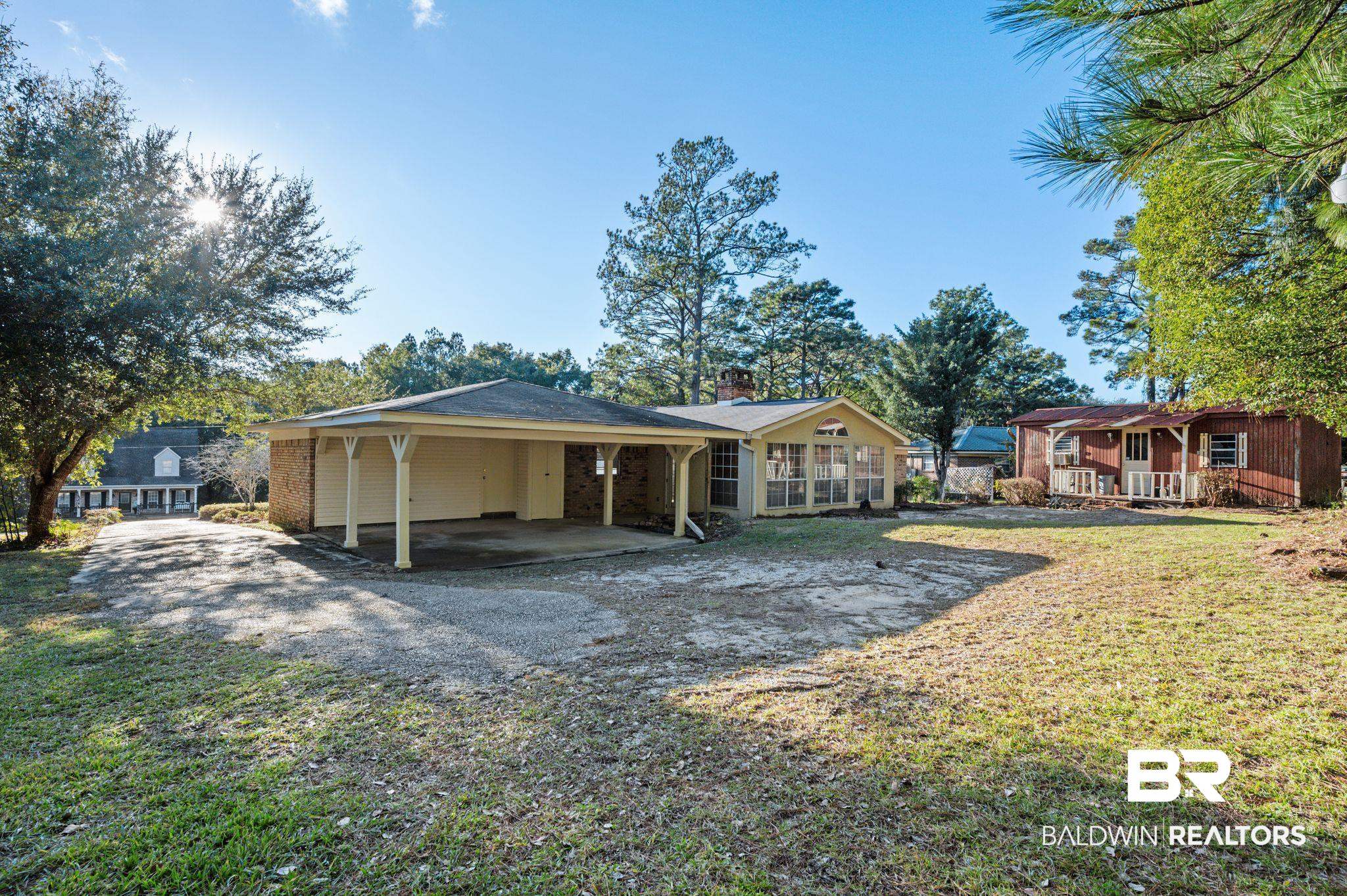 909 Caroline Avenue Daphne, AL 36526 - Photo 39 of 46 Rear view of house featuring a carport and a lawn