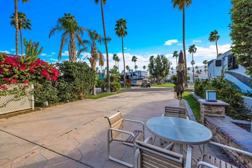 a view of a patio with table and chairs potted plants