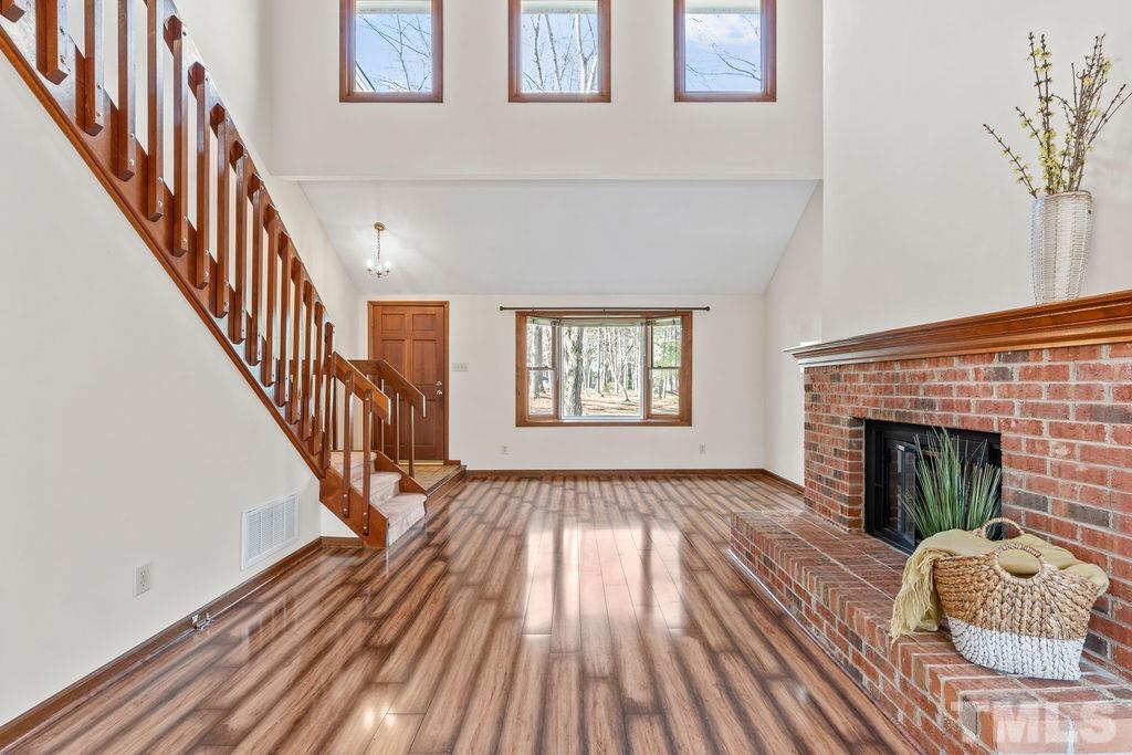 1014 Boathouse Court Raleigh, NC 27615 - Photo 7 of 41 a view of an empty room with wooden floor fireplace and a window