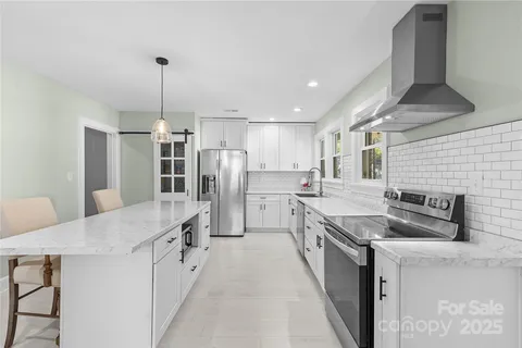 a kitchen with stainless steel appliances granite countertop a sink refrigerator and cabinets