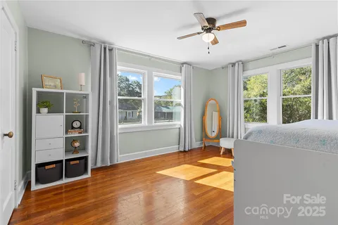 a view of an empty room with window and a kitchen