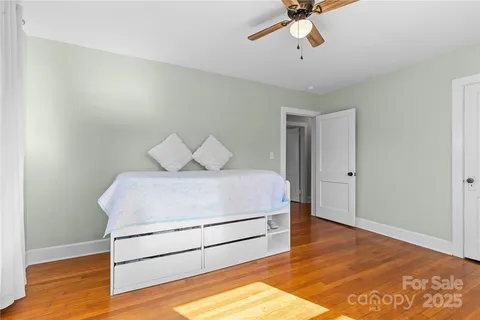 a room with a bed and wooden floor