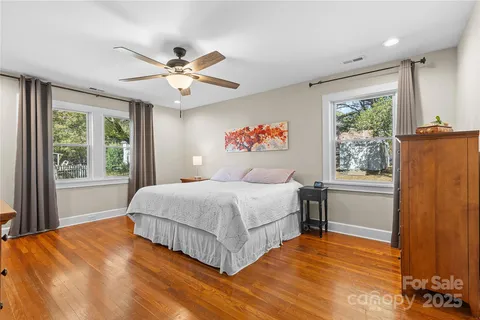 a bedroom with a large bed chandelier and a window