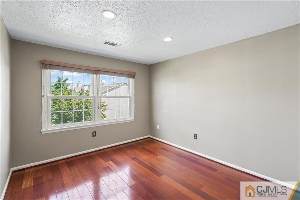 834 Edpas Road, Unit 834 New Brunswick, NJ 08901 - Photo 10 of 20 an empty room with wooden floor and windows