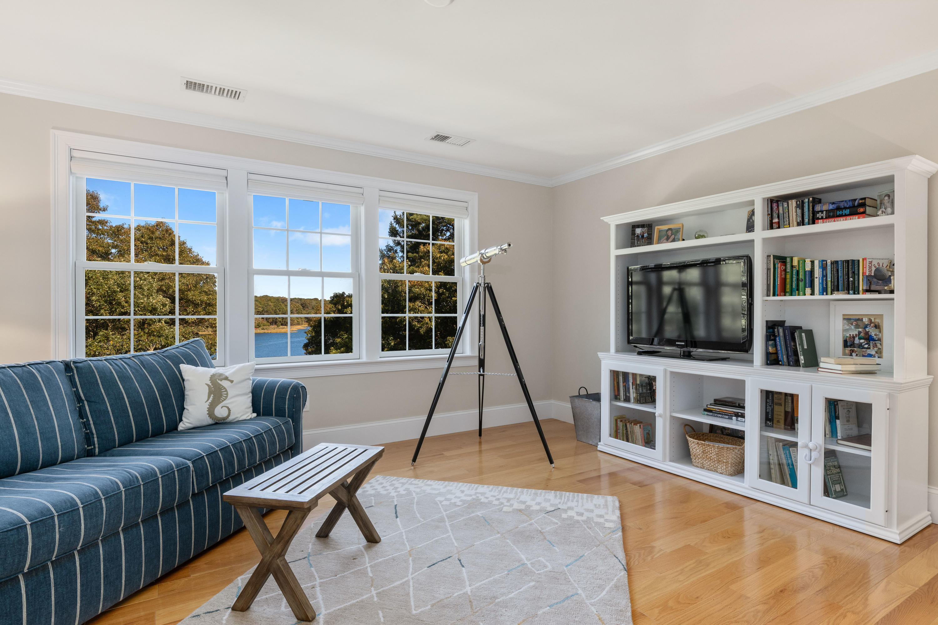 134 Namequoit Road Orleans, MA 02653 - Photo 42 of 69 a living room with furniture a flat screen tv and a book shelf